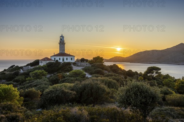 Lighthouse at sunset, surrounded by green hills and sea, Lastovo, Neretva, Croatia, Europe