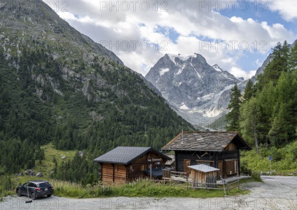 Wooden houses in the mountain village of Arolla, behind mountain peak Mont Collon, Valais, Western Alps, Switzerland, Europe