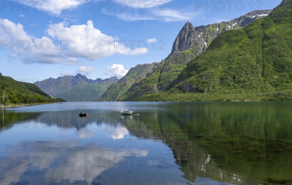 Small boats at the fjord Austnesfjorden, idyllic Norwegian fjord landscape, mountains reflected in the water, Sildpollen, Nordland, Norway, Europe