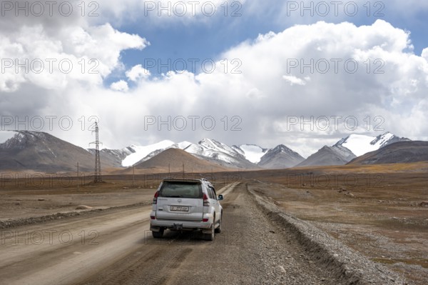 Off-road vehicle on a gravel track, glaciated and snow-covered peaks, Ak Shyrak Mountains, near Kumtor, Kara-Say, Tian Shan, Kyrgyzstan, Asia