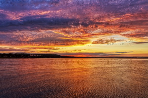 Colourful sunset with dramatic sky over calm sea, Rügen
