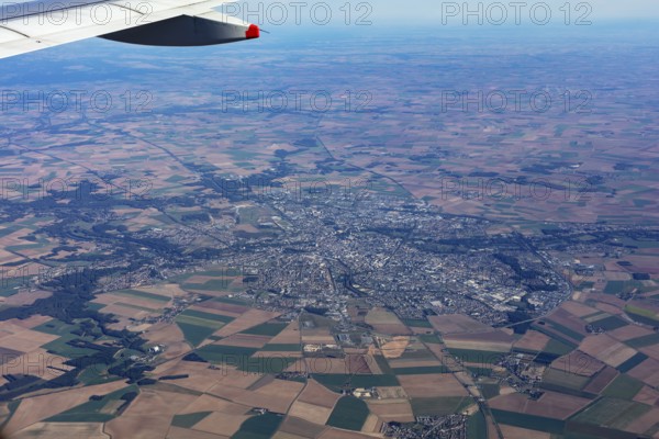 View from an aeroplane over fields and a cityscape, flight, aerial view