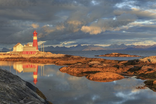 Lighthouse reflected in water, morning light, clouds, mountains, coast, Tranoy, Ofoten, Norway, Europe