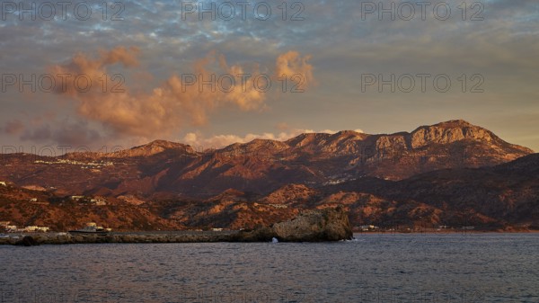 Impressive coastal scene at sunrise with mountains and dramatic clouds in the sky, Pigadia, town and harbour, Pigadia Bay, main town, Karpathos, Dodecanese, Greek Islands, Greece, Europe