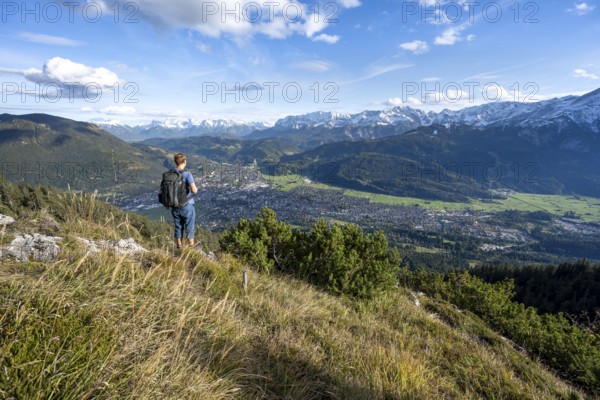 View of Garmisch-Partenkirchen and mountain panorama, mountaineer on hiking trail to Kramerspitz, in autumn, Ammergau Alps, in autumn, Bavarian Prealps, Bavaria, Germany, Europe