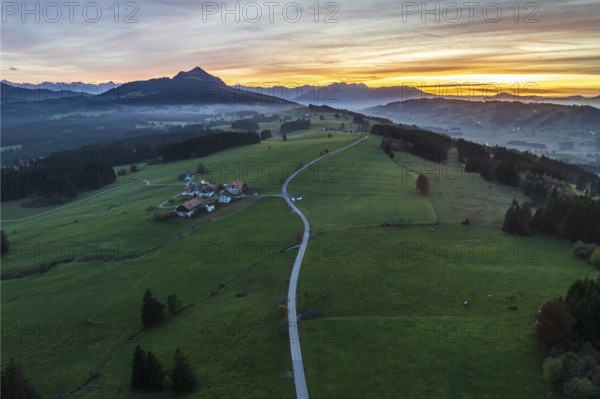 Mountain range near village Wertach, view to mt. Gruenten, sunset, fog in valley, traditional farm, aerial view, Allgaeu, Bavaria, Germany, Europe