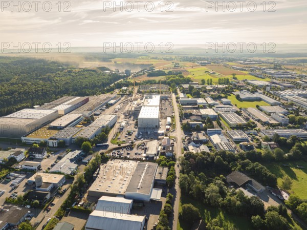 Numerous buildings and streets in an industrial area, surrounded by wooded landscape under a sunny sky, Wolfsberg industrial area, Nagold, Black Forest, Germany, Europe