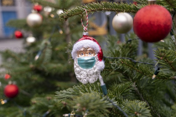 Symbolic image of Christmas in the Corona crisis, Father Christmas figure, Christmas tree decoration, with mouth and nose mask, everyday mask