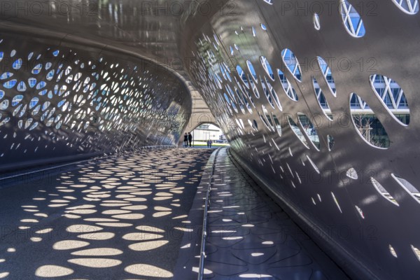 Light effects from the sun in the Parkbruk, a cycle and pedestrian bridge in the city centre of Antwerp, spanning a multi-lane city centre road with tram lines, and thus connecting two lively city districts Kop Spoor Noord and Eilandje, Belgium, without any crossings, Europe