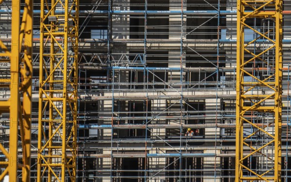 Construction site, at the Cologne Trade Fair Centre, new construction of a high-rise office building, construction cranes, facade of the shell, scaffolding, construction crane, North Rhine-Westphalia, Germany, Europe