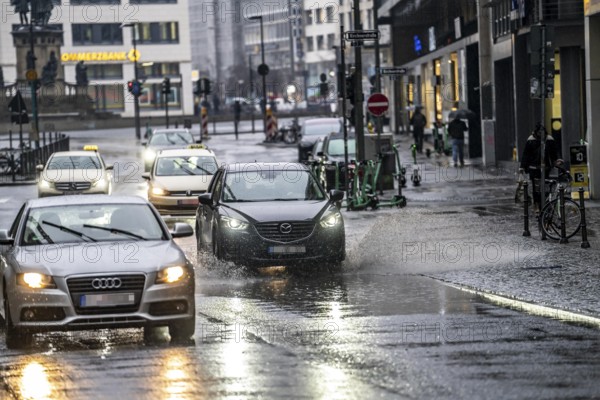 Winter, rainy weather, freezing rain, large puddle, puddle of water, in the city centre, Große Gallusstraße, vehicles driving through, spraying water fountains, Frankfurt am Main, Hesse, Germany, Europe
