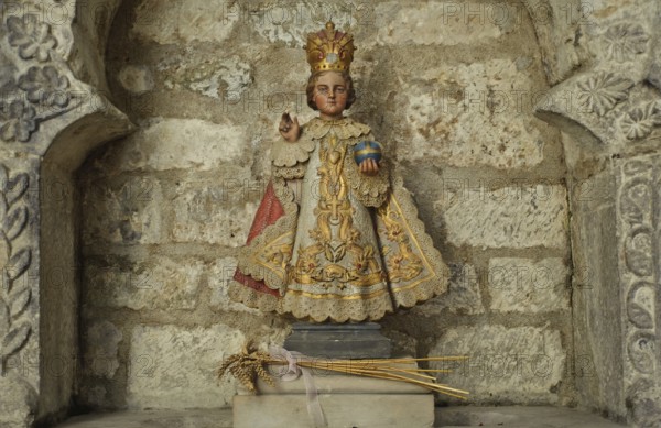 Copy of a statuette representing Jesus Christ as a child. It is called the Little Jesus of Prague. Seen in the Airvault church France