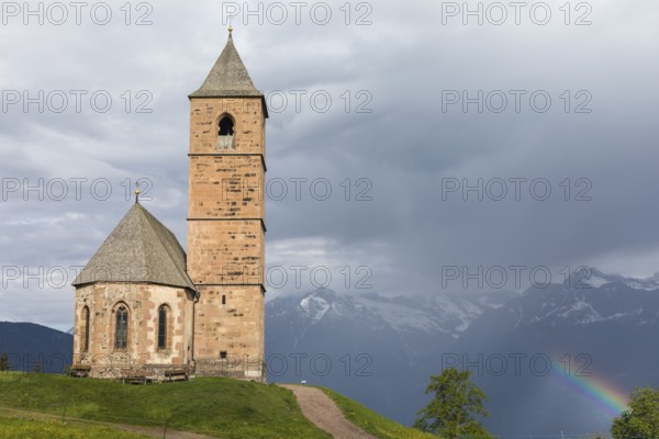 Church St. Kathrein, 39010 Hafling, Italy with a rainbow in the background. The church is from the 13 th century