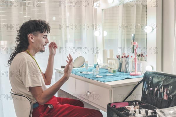 Young male makeup artist applying foundation in front of a mirror at a professional beauty salon, surrounded by makeup tools, highlighting diversity in the beauty industry