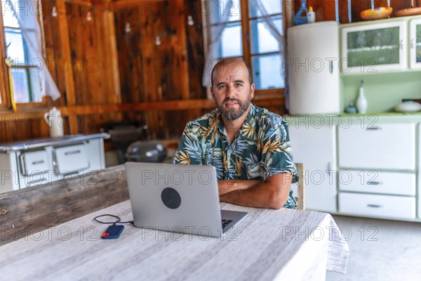 Digital nomad working on laptop in a cozy wooden cabin, embracing freedom and flexibility of remote work