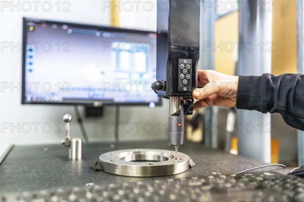 Close-up of the hand of a technician working with three-dimensional verification and measuring machine in a cnc innovative metal factory