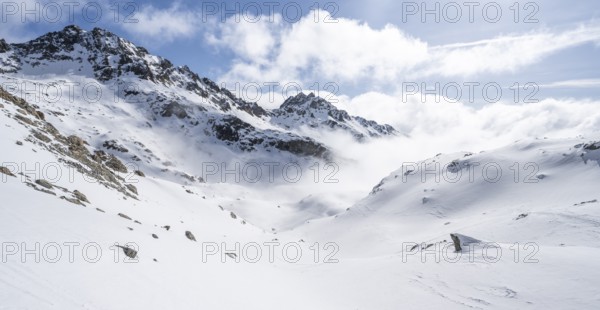 Atmospheric clouds in a wintry mountain landscape, ascent to Porta d'Es-cha, Bündner Haute Route ski tour, Albula Alps, Rhaetian Alps, Grisons, Eastern Switzerland, Switzerland, Europe