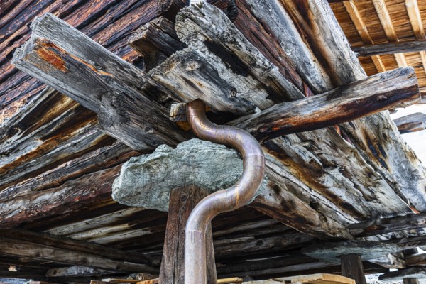 Old weathered hay barn with wooden support, stone slab and copper pipe, Chandolin, Val d'Anniviers, Valais Alps, Canton Valais, Switzerland, Europe