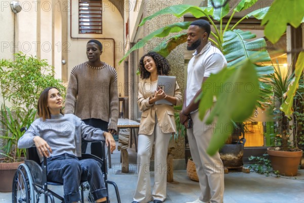 Disabled woman and coworking colleagues talking in a patio of a modern coworking space