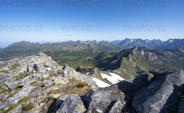 View of mountain landscape, mountain panorama, mountaineer at the summit of Rundfjellet, lake Hellskarvatnet, Svolvaer, Nordland, Norway, Europe