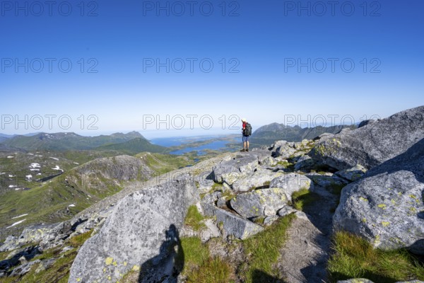 View of mountains and fjord landscape, mountaineer at the summit of Rundfjellet, Svolvaer, Nordland, Norway, Europe