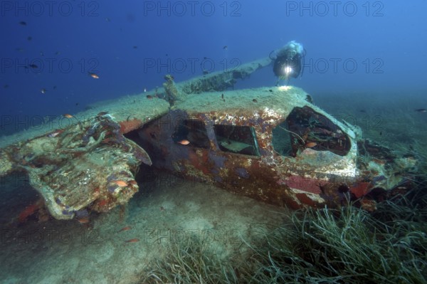 Diver looking at Cessna aircraft wreck underwater on the seabed while scuba diving, Porto Azzurro, Elba, Tuscany, Italy, Europe, Mediterranean Sea, Europe