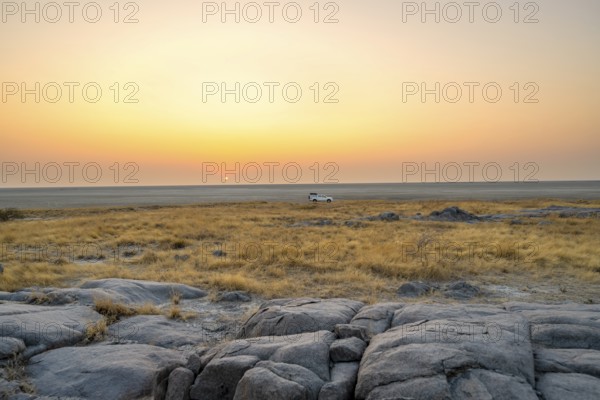 Off-road vehicle on a salt pan, at sunrise, Kubu Island (Lekubu), Sowa Pan, Makgadikgadi Salt Pans, Botswana, Africa