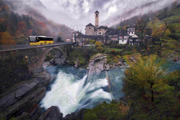 Village view of Lavertezzo on a rainy autumn day, post bus crossing a stone bridge, Verzasca Valley, Canton Ticino, Switzerland, Europe