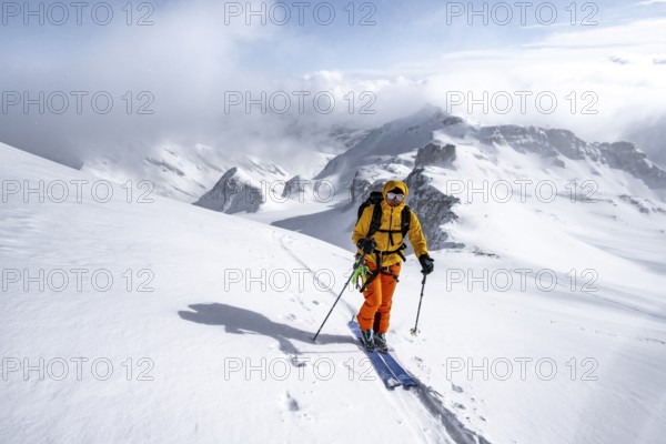 Ski tourers climbing the Wildhorn, Snowy mountain landscape and fog, Bernese Alps, Bernese Oberland, Switzerland, Europe