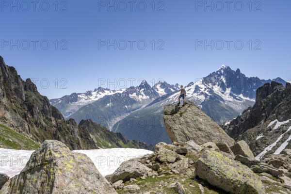 Mountaineer standing on a rock, mountain landscape with mountain peak Aiguille Verte, Mont Blanc massif, Aiguilles Rouges, Chamonix-Mont-Blanc, Haute-Savoie, France, Europe