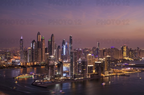 Night shot, view from The View At the Palm viewing platform of skyline with Princess Tower, Elite Residence, luxury yacht OPERA owned by Sheikh Mansour bin Zayed Al Nahyan from the ruling family of the Emirate of Dubai, anchored in front of EMAAR Beachfront, logo, DAMAC, evening mood, Dubai Marina, Dubai, United Arab Emirates, VAR, Asia