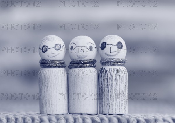 Three small funny wooden cones, monochrome in front of a painted background, North Rhine-Westphalia, Germany, Europe