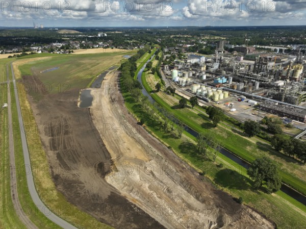 Oberhausen, North Rhine-Westphalia, Germany, renaturalisation of the Emscher in the Holtener Bruch. A new floodplain landscape for flood protection and biodiversity is being created here. On the right, OQ Chemicals plant Ruhrchemie. The Emscher, which is currently straightened, is given curves again and can meander through its new floodplain. The ecological reorganisation of the Emscher system consists of the construction of a central wastewater treatment system in the Ruhr area, the construction of sewers and the renaturation of the Emscher and its tributaries. Following the construction of a parallel sewer, the Emscher has been completely free of sewage since January 2022. The river was previously an open, above-ground combined sewer with rainwater and wastewater, Europe