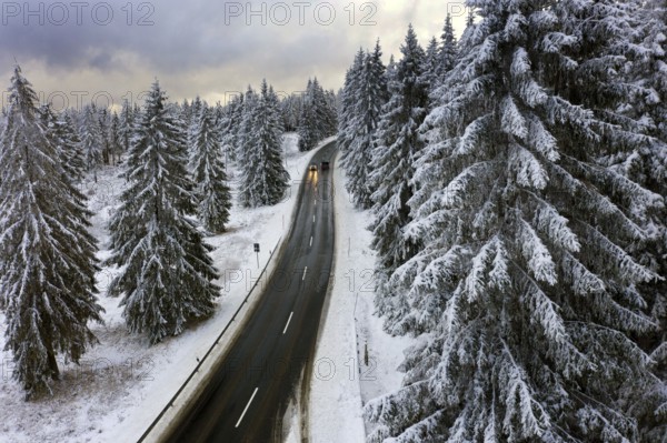 Aerial view, road leads through a snow-covered forest area near Sankt Andreasberg, 14 December 2019