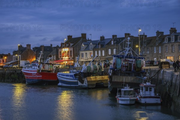 Barfleur, Normandy, France - Fishing boats on the quay in the harbour of Barfleur, a picturesque fishing village, a French commune in the Manche department on the Cotentin peninsula in the Normandy region, behind the famous Café de France