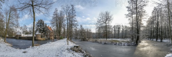 Wide winter landscape near moated castle Haus Welbergen with frozen water and trees, Ochtrup-Welbergen, Münsterland, North Rhine-Westphalia, Germany, Europe