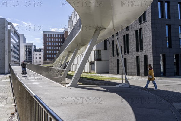 The Parkbruk, cycle and pedestrian bridge in the city centre of Antwerp, crosses a multi-lane city centre road with tram lines and thus connects two lively city districts Kop Spoor Noord and Eilandje, 140 metres of curved ramp on the western side for driving up and down, walking, Belgium, Europe