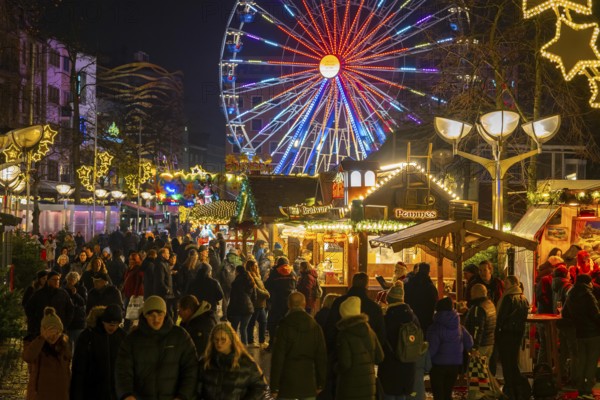 Christmas market on Königsstraße in the city centre of Duisburg, pre-Christmas season, Christmas lights, Ferris wheel, Christmas market stalls, crowds, North Rhine-Westphalia, Germany, Europe