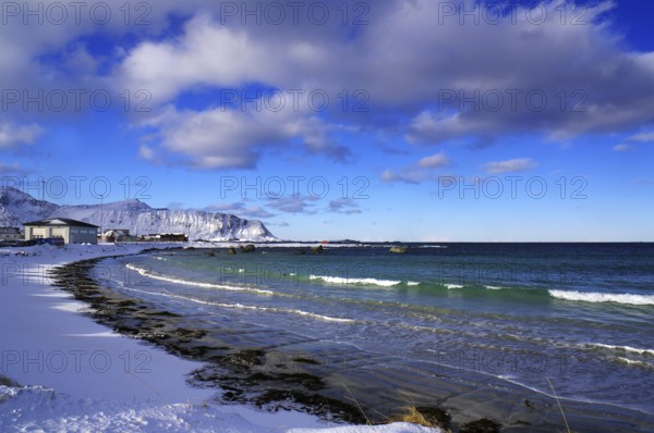 Snowy beach with gentle waves, blue sky and scattered clouds, quiet winter scenery, Ramberg, Flakstad, Lofoten, Nordland, Norway, Europe