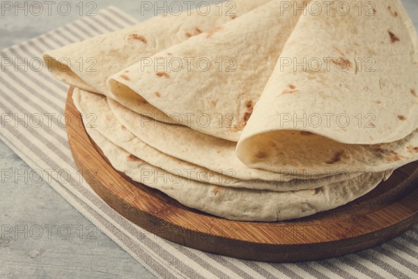 A stack of Mexican tortillas, on a gray table, top view, close-up, no people
