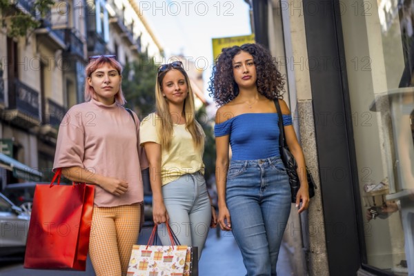 Portrait of three diverse women carrying shopping bags standing in the city