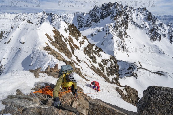 Mountaineer belaying on a steep snow slope, belaying on a rope, ascent to the summit of Piz Grialetsch in winter, view of mountain panorama with snow, Grisons Haute Route, Albula Alps, Rhaetian Alps, Grisons, Switzerland, Europe