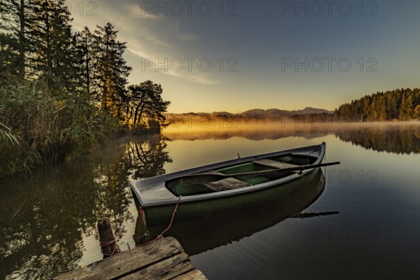 Boats in the autumnal Schmutter Weiher in the Allgäu near the municipalities of Halblech, Roßhaupten and Lechbruck in Ostallgäu in the foothills of the Alps