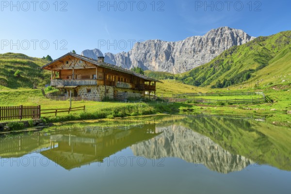 Alpine hut in front of rose garden, reflection, Seiser Alm, Dolomites, South Tyrol