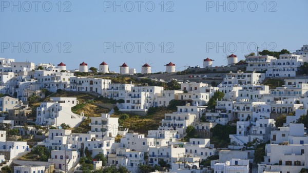 Traditional windmills line up next to white houses on a sunny hillside, Chora, Astypalea, Dodecanese, Greek Islands, Greece, Europe