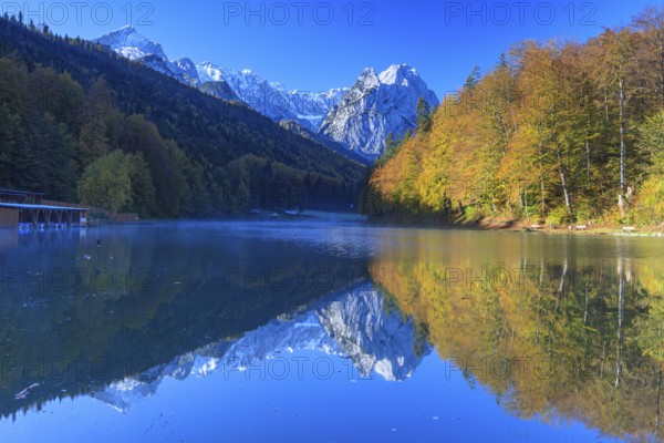 Mountains reflected in lake, fog, morning light, autumn colours, Riessersee, Waxensteine behind, Wetterstein range, Garmisch-Partenkirchen, Bavaria, Germany, Europe