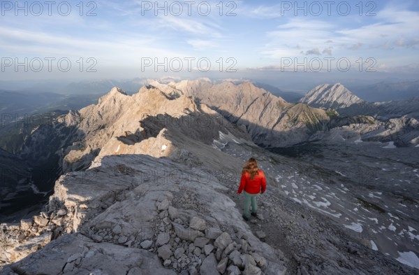 Mountaineer on a steep rocky ridge, impressive mountain landscape, view of the Höllental and the Alpspitze from the Jubiläumsgrat, in the evening light Zugspitze, Wetterstein range, Bavaria, Germany, Europe