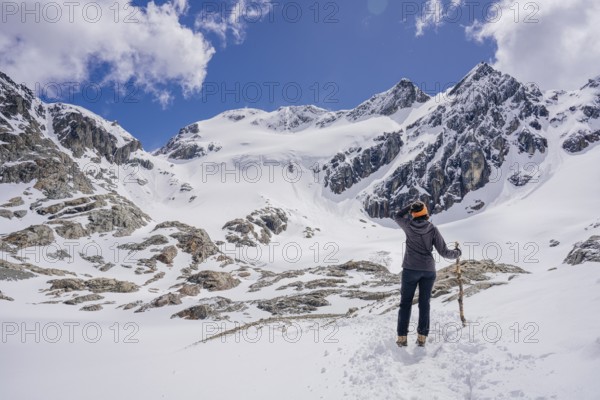 Woman hikes across a snowfield, Glaciar Vinciguerra, Ushuaia, Tierra del Fuego Province, Argentina, Person blickt in eine schneebedeckte Berglandschaft, umgeben von klarem Himmel, Argentinien, South America