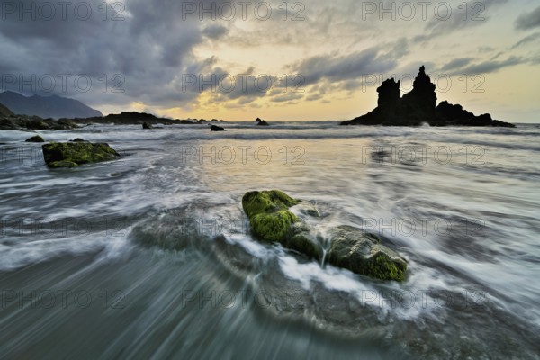 Dramatic cloudy atmosphere with rock formation at rising tide at sunset on the beach of Playa de Benijo, Tenerife, Canary Island, Spain, Europe