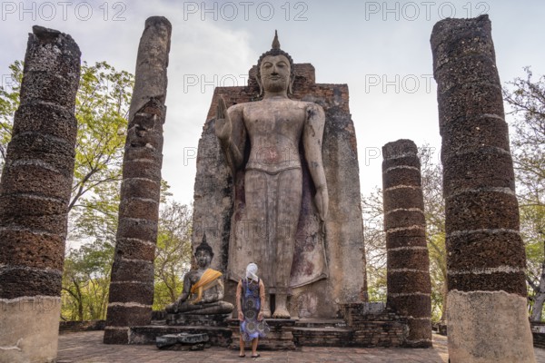 Tourist in front of the giant standing Buddha in the temple Wat Saphan Hin, UNESCO World Heritage Sukhothai Historical Park, Thailand, Asia